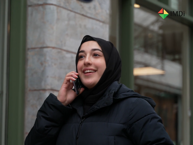 En kvinne i hijab som snakker i mobiltelefonen.